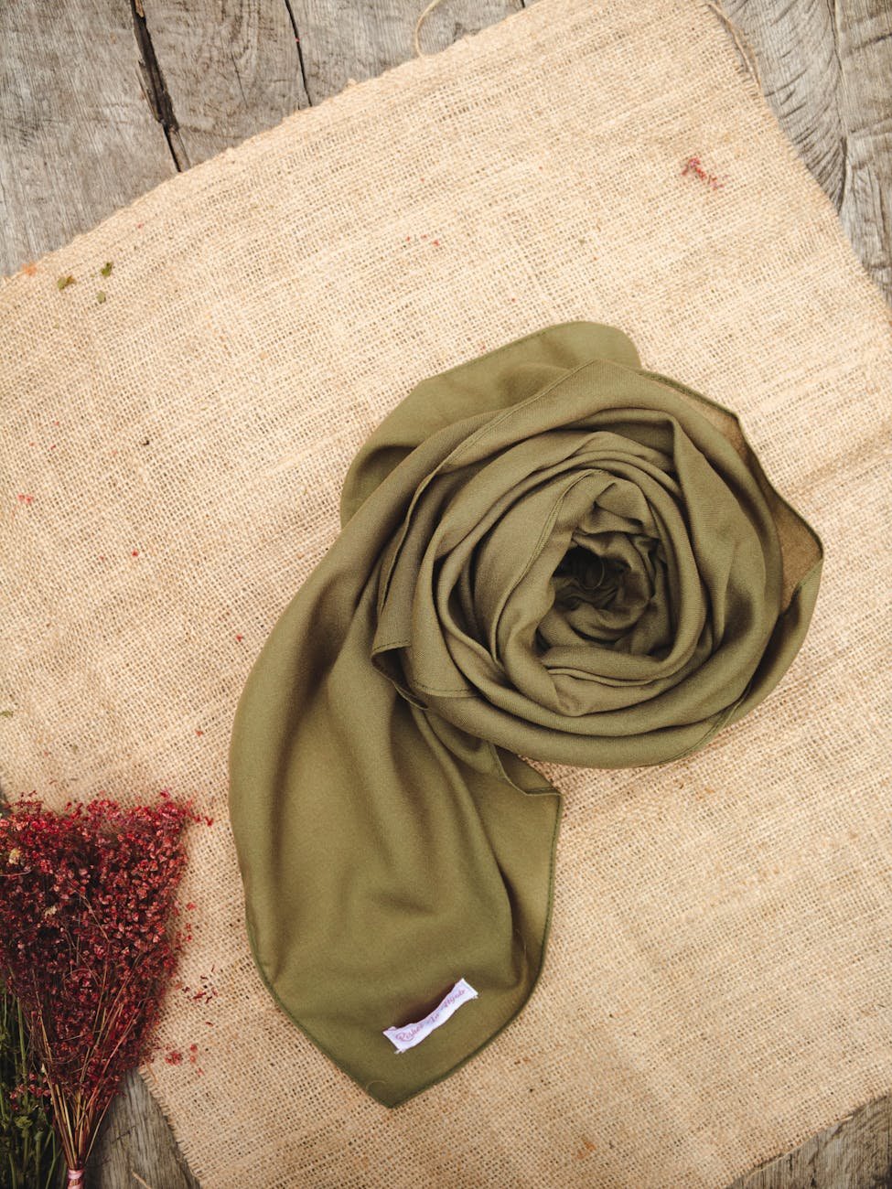 A handcrafted Pashmina shawl rolled on natural burlap — showcasing the fineness of Himalayan fibre