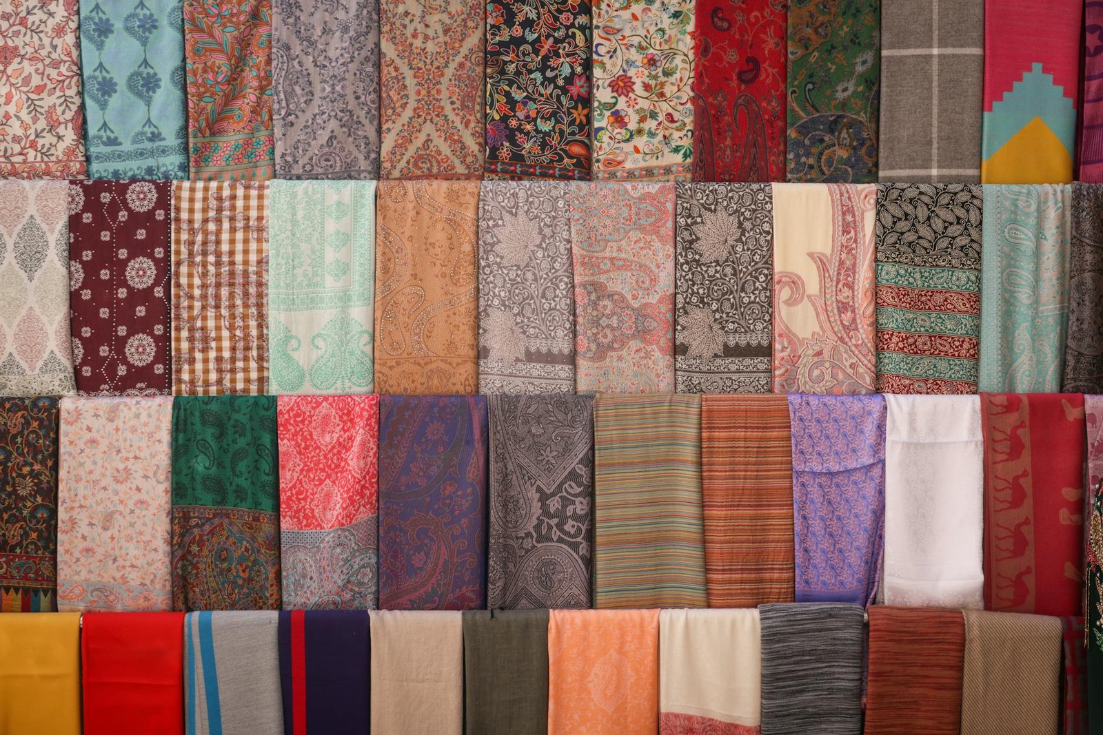 A vibrant display of hand-woven textiles and carpets — representing Rita Industries' product range